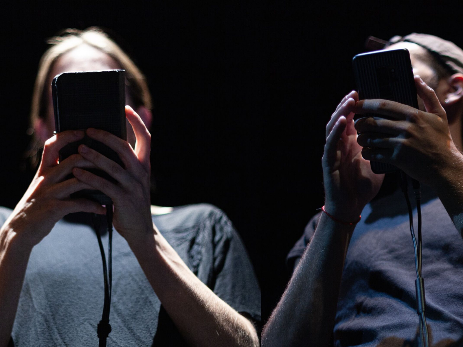 Zwei Personen hinter Handys