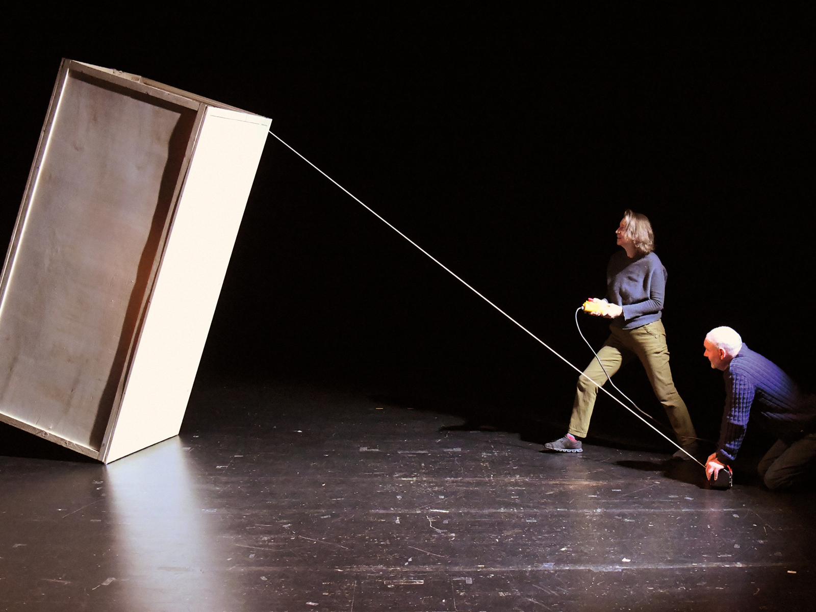 Zwei Spieler ziehen mit einem Seil an einer grißen Box die fast umkippt.