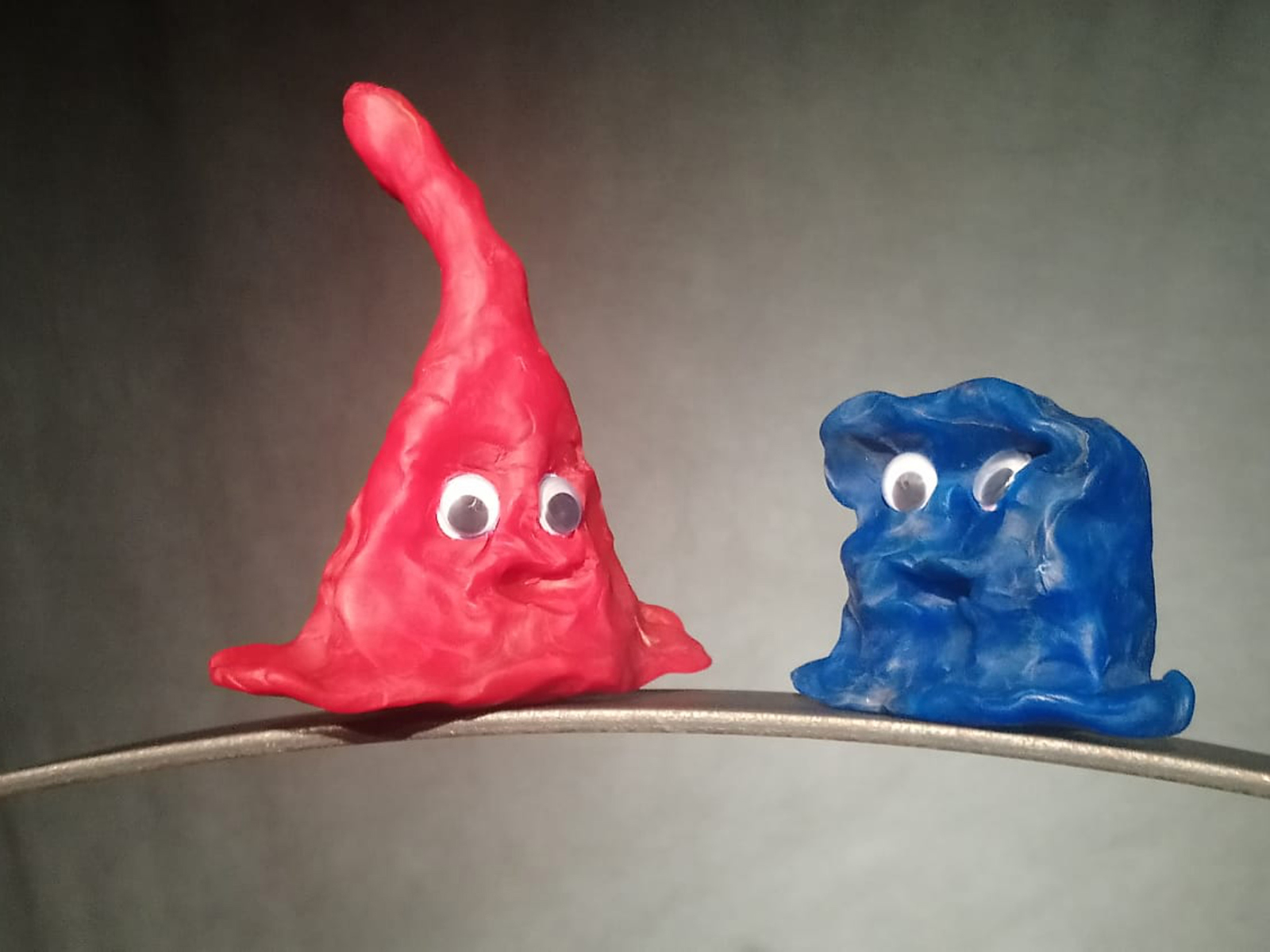 Ein blaue und eine rote Knetfigur mit Augen nah nebeneinander