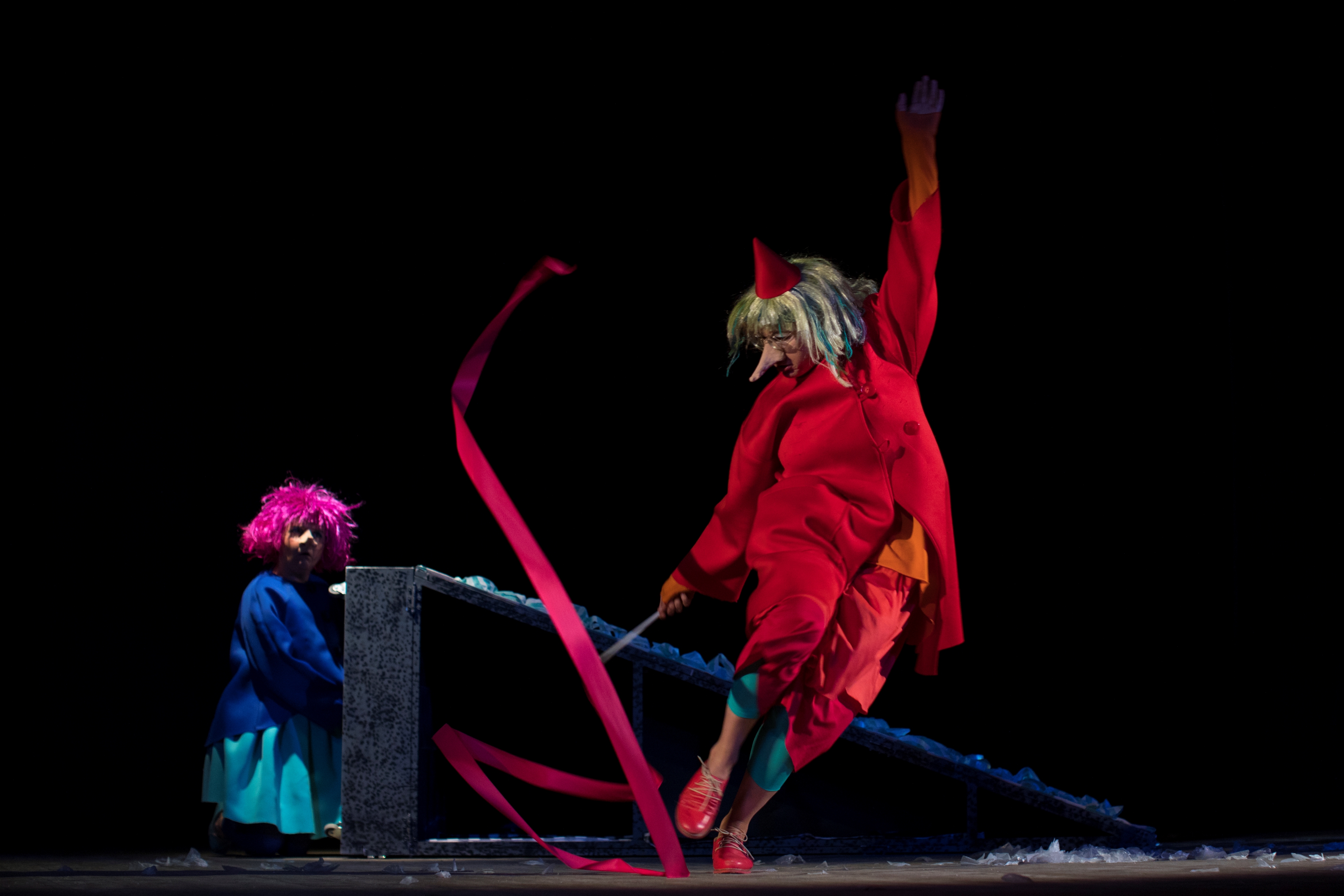 Ein Mumin gekleidet in Rot schwingt ein rotes Band.