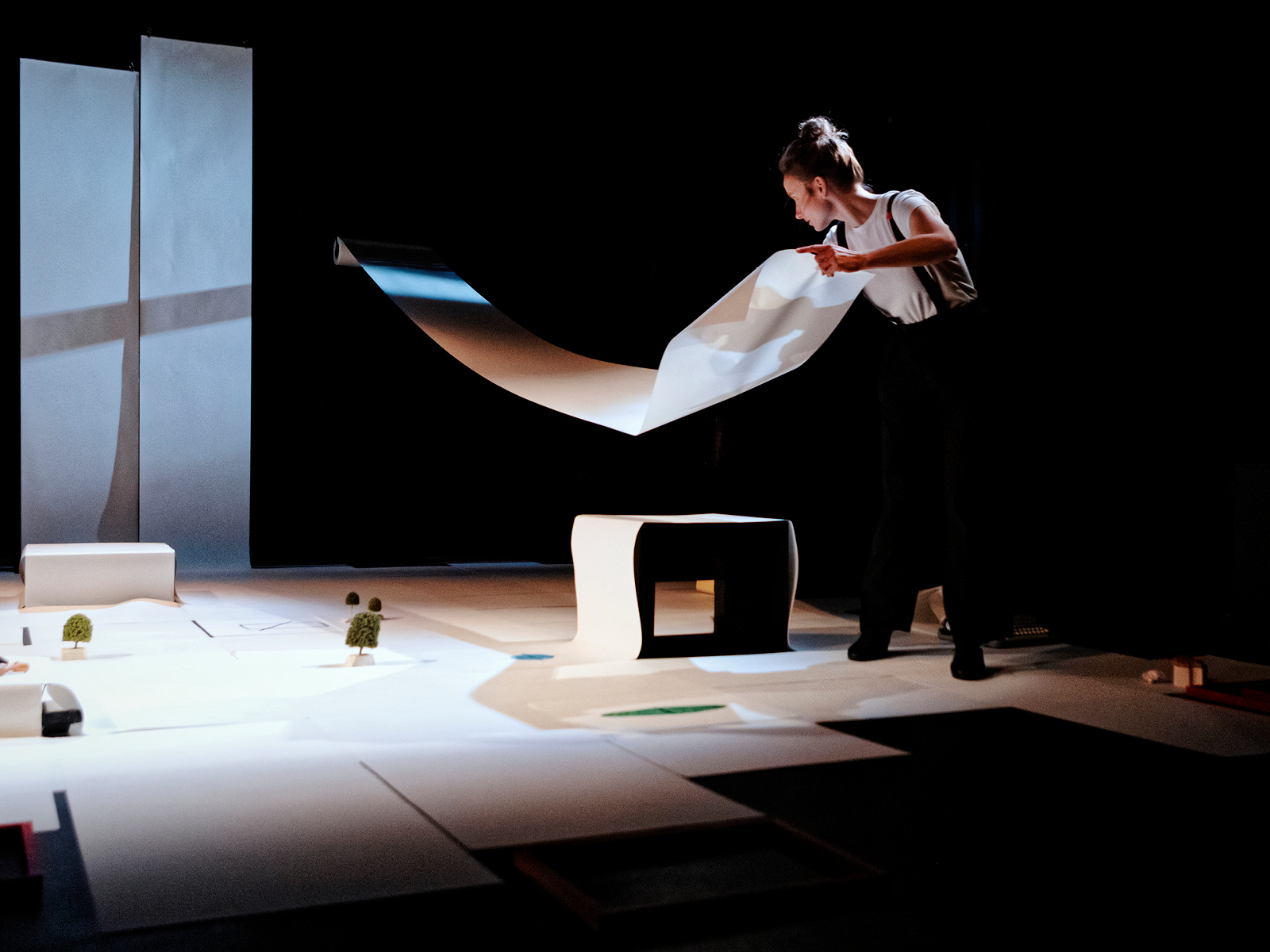 Spielerin breitet eine Papierbahn in der Luft aus.